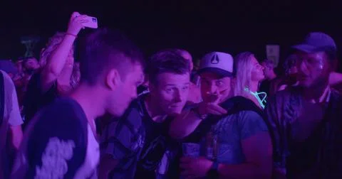 Group ravers huddle together dance-flour. Jumping people electronic dance music 스톡 사진