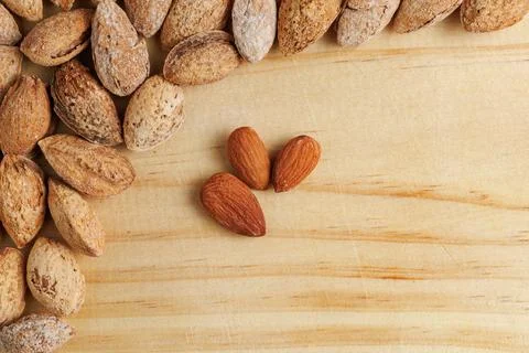 Group of raw almonds with negative space on wooden board Stock Photos
