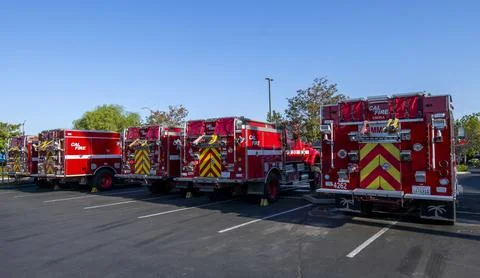 A group of red Cal Fire fire engine trucks in parking lot. First responders Stock Photos