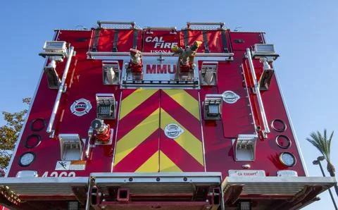 A group of red Cal Fire fire engine trucks in parking lot. First responders Stock Photos