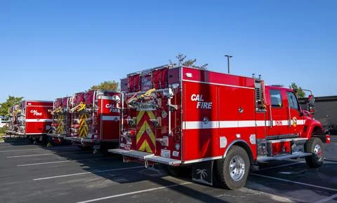 A group of red Cal Fire fire engine trucks in parking lot. First responders Foto stock