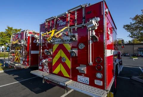 A group of red Cal Fire fire engine trucks in parking lot. First responders Stock Photos