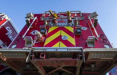 A group of red Cal Fire fire engine trucks in parking lot. First responders Stock Photos