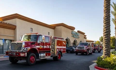 A group of red Cal Fire fire engine trucks in parking lot. First responders Stock Photos