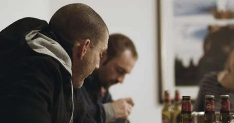 Group of Red Chargers sitting at table eating and telling stories while laughing Stock Footage 160568015
