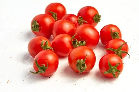 Group of red cherry tomatoes, ripe organic tomatoes on a light wooden backg.. Stock Photos
