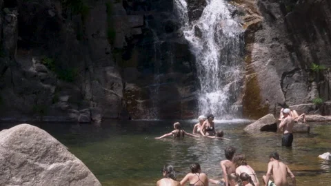 Group Relaxing at Waterfall Pool Surrounded by Stunning Natural Rock Formations Stock Footage 317159114
