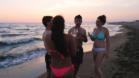 Group of riend toasting on the beach at the sunset Stock Footage 77339601