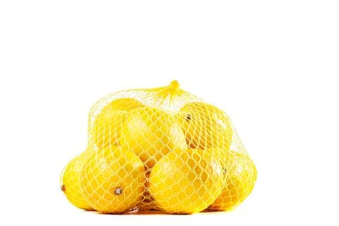 Group of ripe lemons in a mesh bag against white background Stock Photos
