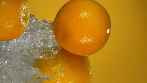 Group of ripe oranges are bouncing horizontally with water splashes Stock Footage 172063979