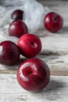 Group of ripe plums on white rustic table Stock Photos