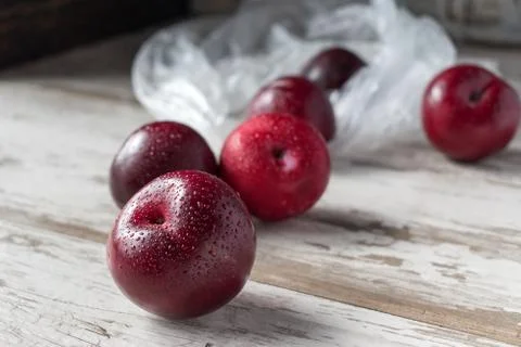Group of ripe plums on white rustic table Stock Photos