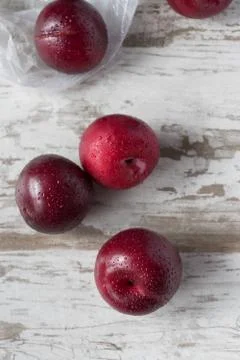 Group of ripe plums on white rustic table Stock Photos
