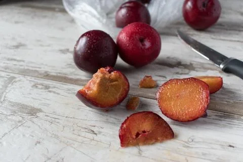 Group of ripe plums on white rustic table Stock Photos