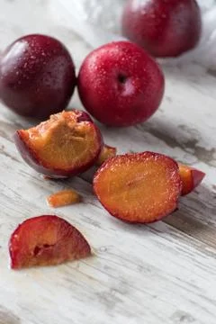 Group of ripe plums on white rustic table Stock Photos