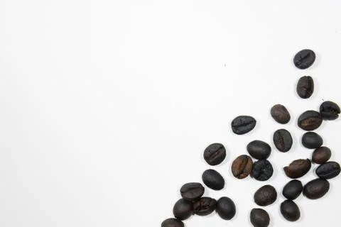 Group of roasted coffee beans at bottom right on white background Stock Photos