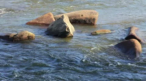 Group of rocks in shallow blue river water Stock Footage 11058734