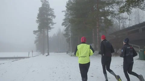 Group of runners jogging along a snow covered path in Finland Stock Footage 146282391