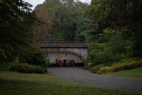 A group of runners jogging under a bridge at central park, New York Stock Photos