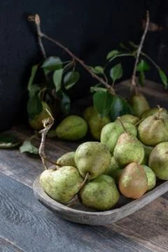 Group of rustic pears with stems and leaves on rustic farm table Foto stock