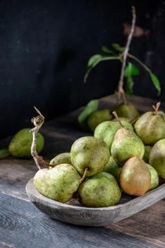 Group of rustic pears with stems and leaves on rustic farm table Stock Photos