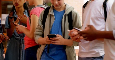 Group of school friends using mobile phone 4k Stock Footage 82302828