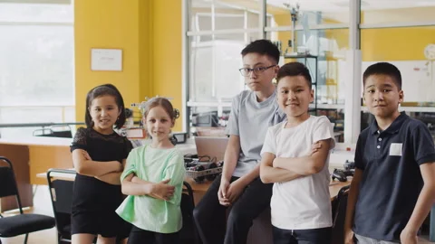 Group of schoolchildren staying, posing for camera and smiling in programming at Stock Footage 244166773