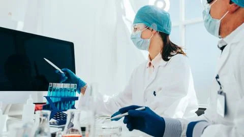 Group of scientists looking at a computer screen in the laboratory. Stock Photos