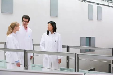Group of  scientists talking in atrium Stock Photos