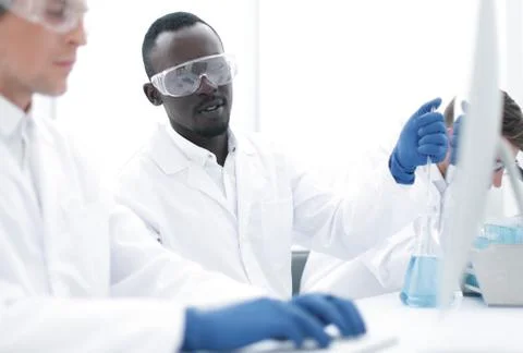 Group of scientists using a computer to enter data Stock Photos