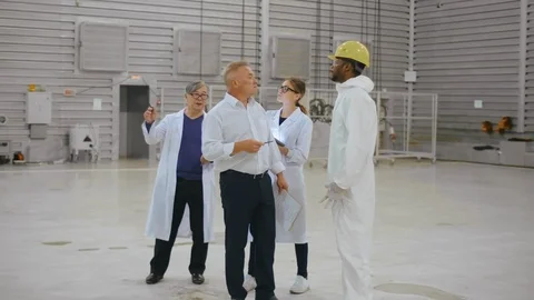 Group of scientists in white robes visit modern research laboratory of heavy Stock Footage 121869265