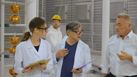 Group of scientists in white robes visit modern energy research laboratory of Stock Footage 121869630