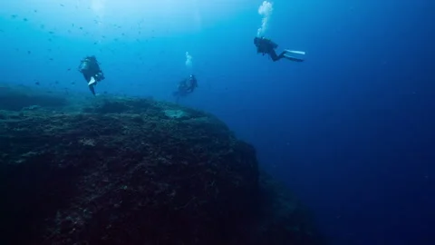 Group of SCUBA Divers drifting in strong current towards deep reef in Peleliu Stock Footage 344060036