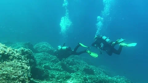 Group of Scuba Divers Exploring Deep Underwater World in 4K Stock Footage 324510396