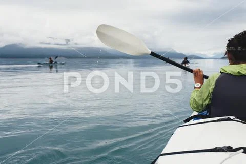 Group of sea kayakers paddling pristine waters of an inlet on the Alaska Stock Photos