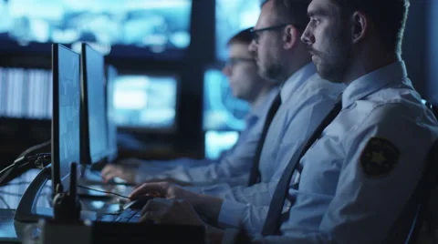 Group of security officers are working in dark monitoring room with displays 스톡 동영상 59612314