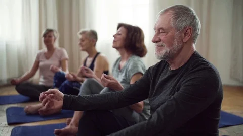 Group of senior people doing yoga exercise in community center club. Stock Footage