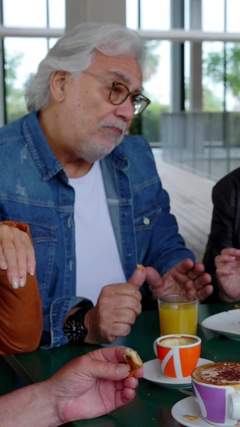 Group of senior people sitting at table enjoying breakfast in the morning Stock Footage 312235079