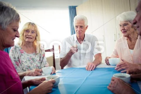 Group Of Seniors Drinking Coffee In The Retirement House