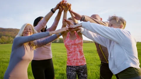 Group of seniors with sport instructor stacking hands after exercise outdoors in Video stock 158168956