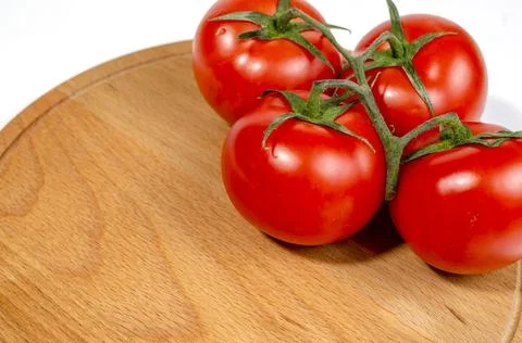 Group of several red tomatoes isolated on wooden board Foto stock