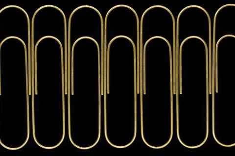 Group of sharp and clear view of golden paperclips standing in line on black Stock Photos