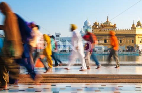 Group of sikh pilgrims walking by the golden temple Stock Photos