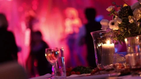 Group of silhouetted people dancing in a dark banquet hall for a wedding Stock Footage 84556952