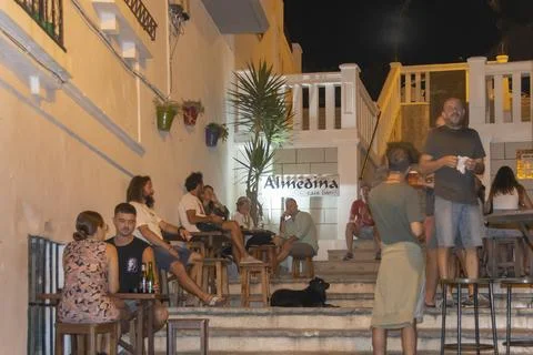 Group sitting on steps outside building, Tarifa, Spain Stock-Fotos