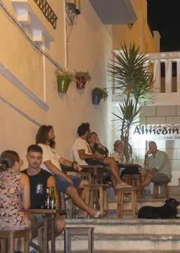 Group sitting on steps outside building, Tarifa, Spain Stock-Fotos