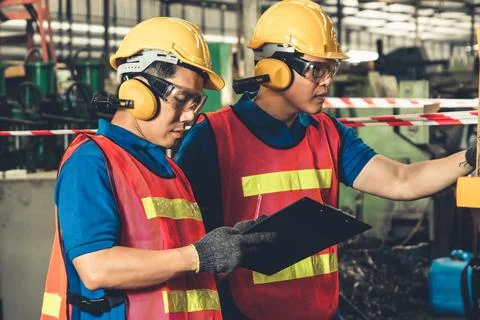Group of skillful factory workers using machine equipment in workshop Fotos Stock