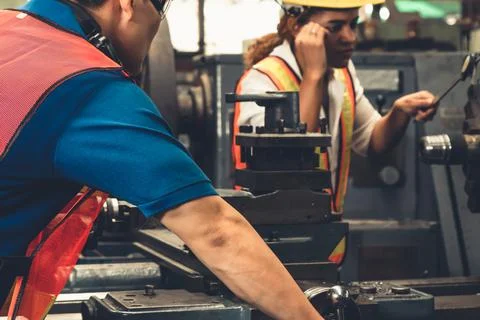 Group of skillful workers using machine equipment in factory workshop Stock Photos