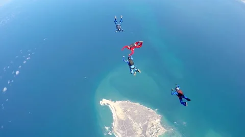 Group of skydivers are hovering in accelerated free fall above coastal city Video stock 60841075