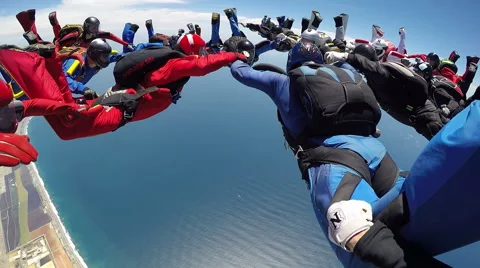 Group of skydivers are hovering in accelerated free fall above coastal city Video stock 60841337